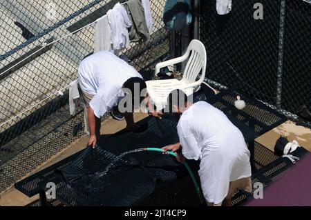 Deux détenus lavent un tapis dans la zone de loisirs en plein air du Camp six de la Force opérationnelle interarmées de Guantanamo Banque D'Images