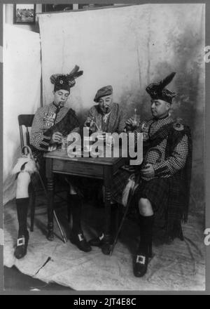 Deux hommes portant le kilt et l'homme fumeur de cigare, assis à une petite table boire Sandy MacDonald scotch Banque D'Images