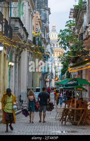 Une image de piétons marchant le long d'une route étroite flanquée de bâtiments betwee à la Havane, Cuba. Banque D'Images