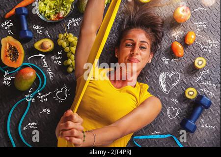 Une femme heureuse mange en bonne santé et s'entraîne dans la salle de gym Banque D'Images