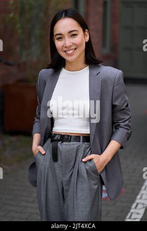 Jeune élégant souriant élégant femme d'affaires asiatique, portrait vertical. Banque D'Images