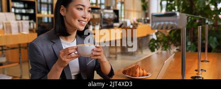 Bonne jeune femme d'affaires asiatique ayant une pause-café travaillant dans un café. Banque D'Images