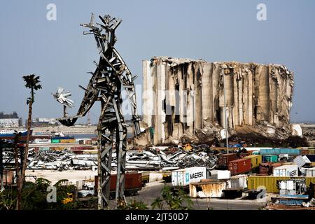 Beyrouth, Liban : devant les silos à grains détruits, se dresse la sculpture en acier de l'artiste Nadim Karam commémorant les victimes de l'explosion mortelle de 4 août 2020, faite de ferraille à partir de l'explosion massive de 2 750 tonnes de nitrate d'ammonium stockées dans le port. Banque D'Images