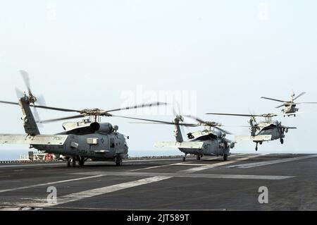 Les hélicoptères Seahawk MH-60s de la Marine américaine affectés à l'Escadron de combat en mer (HSC) 9 et les hélicoptères Seahawk MH-60R affectés à l'Escadron de frappe maritime (HSM) 70 de l'hélicoptère prennent le décollage du pont de vol 141018 Banque D'Images