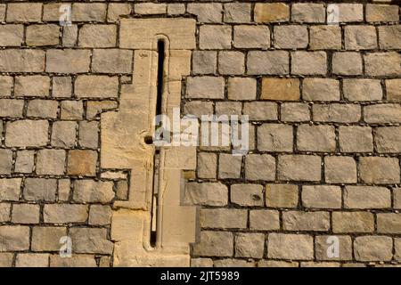 Détail gros plan de la tour du château médiéval avec mur en pierre de maçonnerie massif et trou de boucle à utiliser comme arrière-plan Banque D'Images