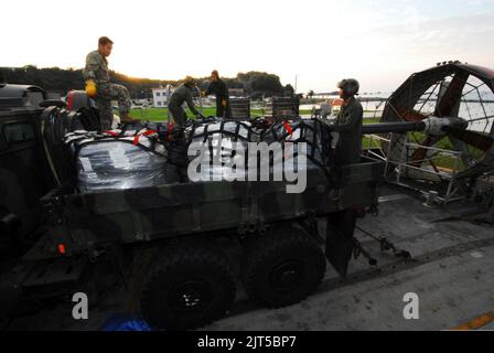 Les marins américains affectés à l'unité Naval Beach 7 utilisent des filets de cargaison pour fixer le fil barbelé à un véhicule tactique de remplacement moyen du corps des Marines à bord d'un embarcation de la Marine américaine, coussin d'air le 16 novembre 2013, on 131116 Banque D'Images