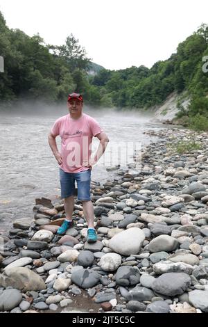 Homme posant sur la rive de la rivière Belaya, Adygea Banque D'Images