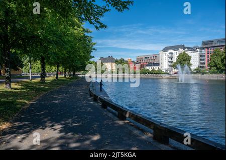 Homme pêchant sur le front de mer de Norrkoping dans le ruisseau Motala début août 2022. Norrkoping est une ville industrielle historique de Suède. Banque D'Images