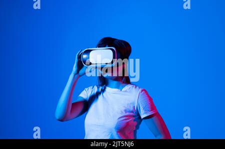 Jeune femme portant un casque VR tout en travaillant avec un projet d'ingénierie en laboratoire avec impression tridimensionnelle. Concept d'ingénierie de haute technologie. Banque D'Images