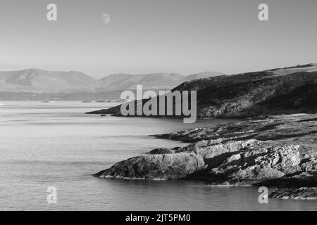 Vue de point Lynas en direction de Snowdonia. Anglesey, pays de Galles du Nord, Royaume-Uni. Banque D'Images