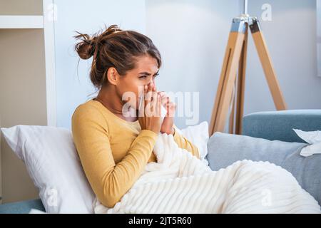 Femme malade.grippe.femme attrapé froid. Éternuer dans les tissus. Maux de tête. Virus .médicaments. Jeune femme infectée par le froid soufflant son nez à Handkerchief. S Banque D'Images