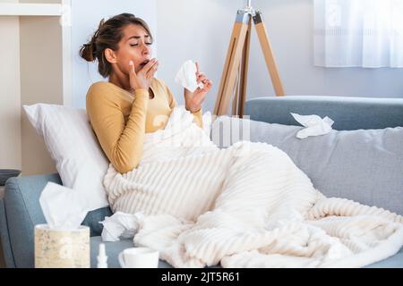 Femme malade.grippe.femme attrapé froid. Éternuer dans les tissus. Maux de tête. Virus .médicaments. Jeune femme infectée par le froid soufflant son nez à Handkerchief. S Banque D'Images