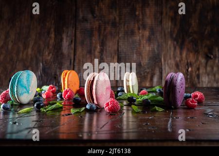 Biscuits de macaron multicolores. Macarons et baies de couleur. Photo colorée avec macarons colorés. Banque D'Images