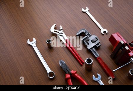 Ensemble d'outils matériels rouges et gris sur fond en bois. Banque D'Images