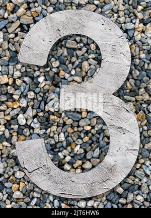 Numéro 3 avec texture de béton, sur fond de pierres Banque D'Images