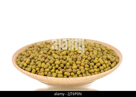 Beaucoup de haricots mungs organiques non cuits dans une soucoupe en céramique, gros plan, isolés sur un fond blanc. Banque D'Images