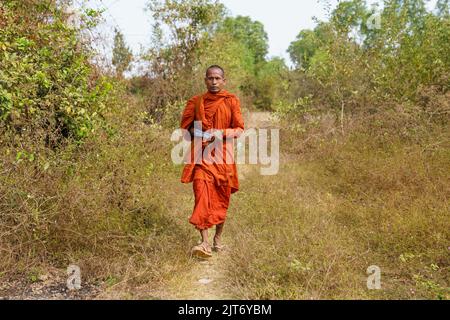 Un moine bouddhiste marchant le long d'un chemin dans la province rurale de Takeo, au Cambodge Banque D'Images