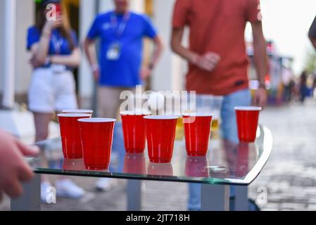 Les gens jouent au Beer pong sur une table au bar. Rue de nuit Banque D'Images