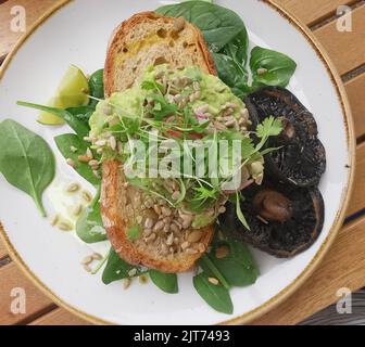 Repas à base de plantes de purée d'avocats sur levain avec champignons Banque D'Images