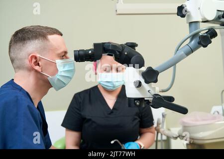 Dentiste pédiatrique effectuant une intervention dentaire assisté par une infirmière Banque D'Images