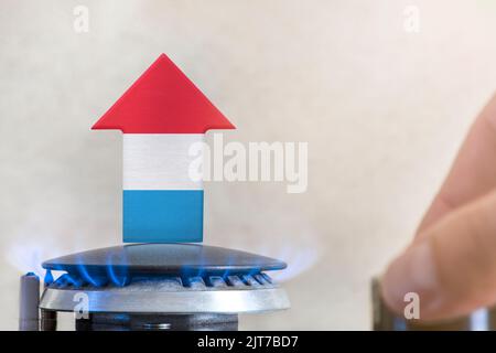 Prix de l'essence. Hausse des prix du gaz au Luxembourg. Un brûleur avec une flamme et une flèche vers le haut, peint dans les couleurs du drapeau luxembourgeois. Le concept de Banque D'Images