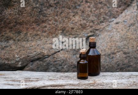 Petite bouteille de médecine en verre brun sur fond de bois vieilli. Banque D'Images