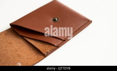 Ouvrez le porte-carte vide en cuir orange véritable sur une surface blanche. Banque D'Images