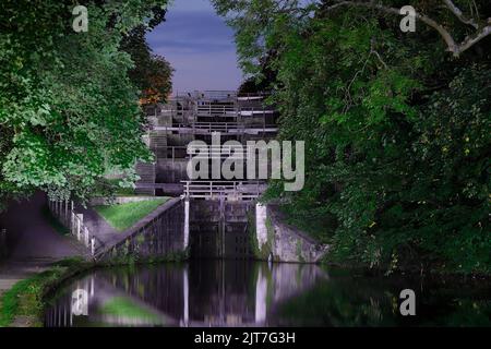 Cinq écluses illuminées par une lampe torche la nuit à Bingley, West Yorkshire. Banque D'Images