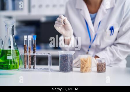 Jeune scientifique tenant une brucelle debout au laboratoire Banque D'Images