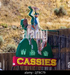 Panneau au néon en bord de route d'un bronco et d'un cowboy pour le Cassie's Bar and Lounge à Cody, Wyoming. Banque D'Images