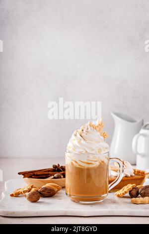 Latte aux épices à la citrouille recouverte de crème fouettée et de cannelle Banque D'Images