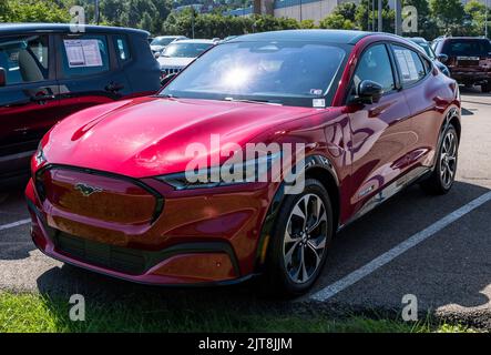 Un vus Mustang Mach-E Premium rouge d'occasion à vendre chez un concessionnaire par une belle journée d'été Banque D'Images