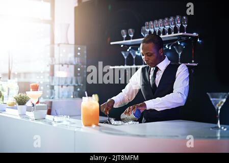 Il suffit de nommer la boisson. Un barman bien habillé debout derrière le comptoir. Banque D'Images