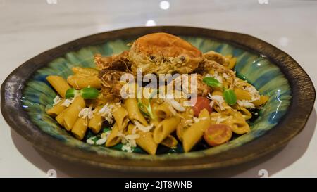 Penne italienne avec poisson et crabe sur le dessus. Pâtes italiennes Banque D'Images