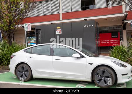 Le modèle 3 de White Tesla est chargé sur un chargeur public Jolt EV à Mona Vale, Sydney, Nouvelle-Galles du Sud, Australie Banque D'Images
