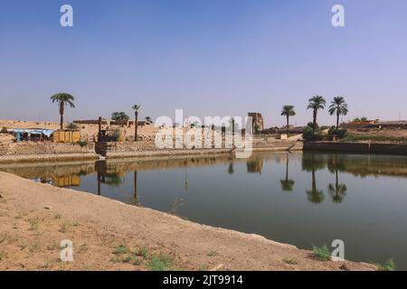 Lac antique dans le complexe du temple de Karnak avec les palmiers autour, Egypte Banque D'Images