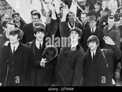 Les Beatles se détournent vers les fans après leur arrivée à l'aéroport Kennedy. United Press International, photographe inconnu. Banque D'Images