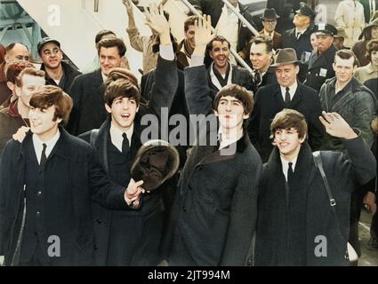 Les Beatles se détournent vers les fans après leur arrivée à l'aéroport Kennedy. United Press International, photographe inconnu. Version colorisée. Banque D'Images