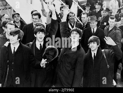 Les Beatles se détournent vers les fans après leur arrivée à l'aéroport Kennedy. United Press International, photographe inconnu. Banque D'Images