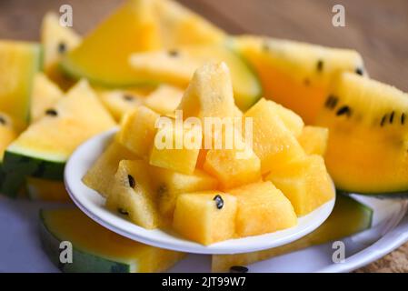 Tranche de pastèque jaune sur fond de plaque blanche, gros plan rondelles de pastèque sucrée morceaux de pastèque frais fruit d'été tropical Banque D'Images