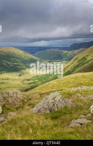 En regardant vers le bas de la vallée de Satura Crag sur la côte à la côte sentier de randonnée longue distance sur le Lake District Fells en été Banque D'Images