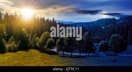 paysage de montagne de carpates au crépuscule d'été. concept de changement de jour et de nuit. belle campagne avec collines boisées et route à travers le va Banque D'Images