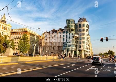 PRAGUE, RÉPUBLIQUE TCHÈQUE - 24 AOÛT 2022. Vue sur la rue au coucher du soleil avec la célèbre Dancing House. Circulation dans les rues de Prague. Banque D'Images