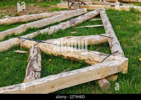 connexion à bande en acier forgé de poutres en bois pour cadre de poutre de support de toit posé sur l'herbe verte le jour de l'été Banque D'Images