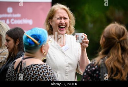 29 août 2022, Berlin: La patronne Lisa Pas (M, Bündnis 90/Die Grünen), ministre fédérale de la famille, des personnes âgées, des femmes et de la jeunesse, discute avec les participants à l'occasion du dévoilement de deux des 15 nouveaux motifs d'affiche de la campagne d'affiches "Knowledge for All" de l'organisation éducative à but non lucratif Goldnetz. Goldnetz conçoit et met en œuvre des mesures et des projets de politique du marché du travail et des femmes à Berlin. Dans la région de Berlin, des panneaux d'affichage grand format montrent des gens que Goldnetz a accompagnés et soutenus dans leur développement professionnel. Photo: Bernd von Jutrczenka/dpa Banque D'Images