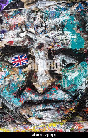 Graffitti sur le mur avec un visage humain et un crossbone de tête de crâne drapeau d'Union Jack Banque D'Images