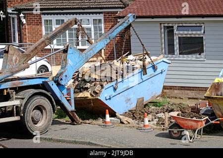 La poubelle des constructeurs complets est sortie du chantier de construction de bungalows compacts sur un camion de saut pour être transporté vers le site de décharge Angleterre Royaume-Uni Banque D'Images