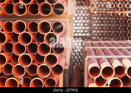 Arrière-plan des tuyaux d'égout en plastique orange utilisés sur le chantier. Texture et motif du tuyau d'évacuation en plastique. Lumière dans les tubes. Banque D'Images