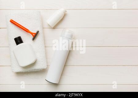 kit homme à raser. machine à raser, serviette, lotion et mousse à raser sur fond coloré. Articles de bain pour hommes vue du dessus. Banque D'Images