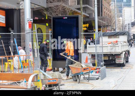 Sydney, Australie travaux de réparation de pavés, hommes posant de nouveaux pavés sur le sentier le long de George Street à Sydney, Nouvelle-Galles du Sud, Australie Banque D'Images